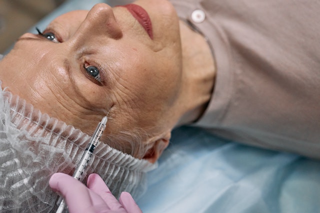 Mature woman facial injections at medical spa.